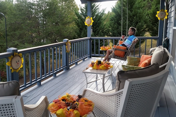 man in wooden deck swing on outside patio deck upper floor outdoor living area