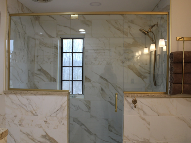 Closeup of bathroom shower area remodeled with gold accents