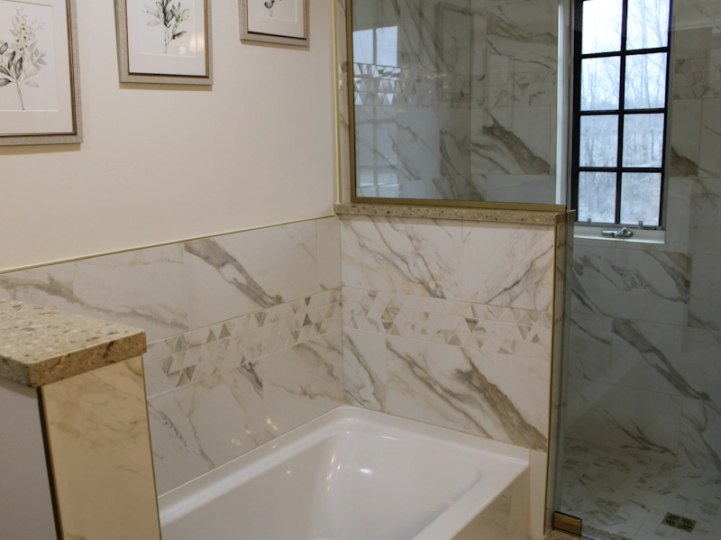 Closeup of bathroom tub and shower remodeling project with gold accents