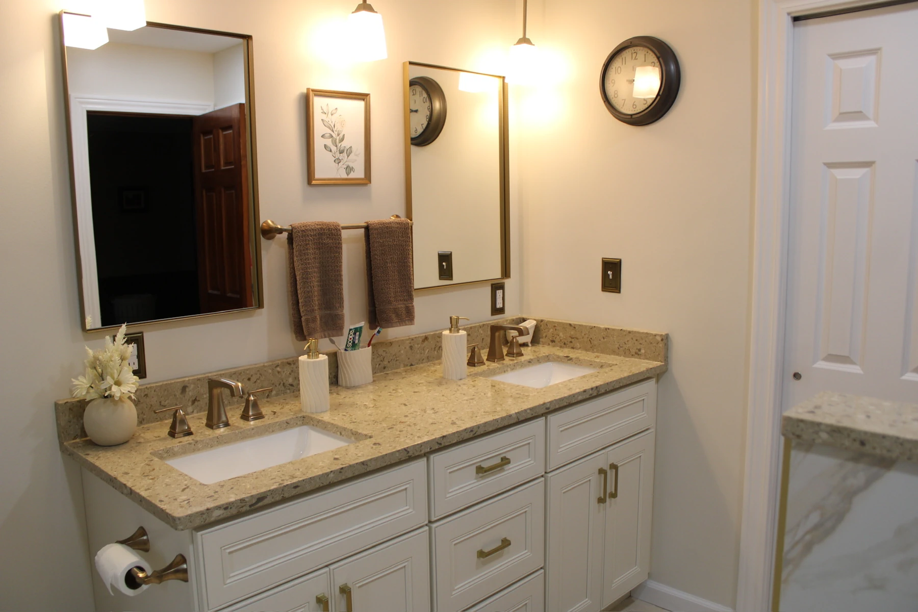 Closeup photo of remodeled bathroom double vanity sink with gold accents