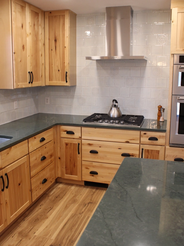 Kitchen remodeling project showing custom backsplash and hood over stove