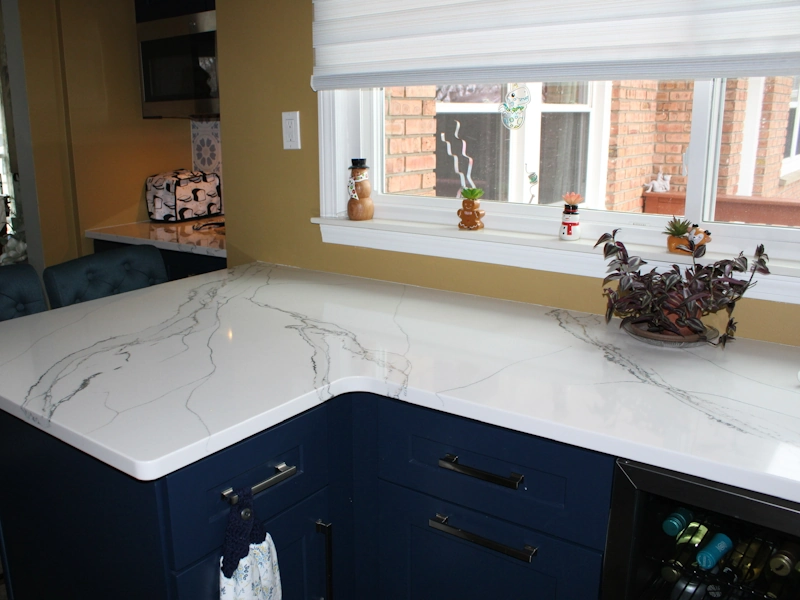 Beautiful veining shown on custom countertop installed over dark blue cabinets in new kitchen