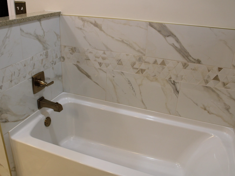 Closeup photo showing custom tile installation of tub surround in bathroom renovation by Lenawee Home Design