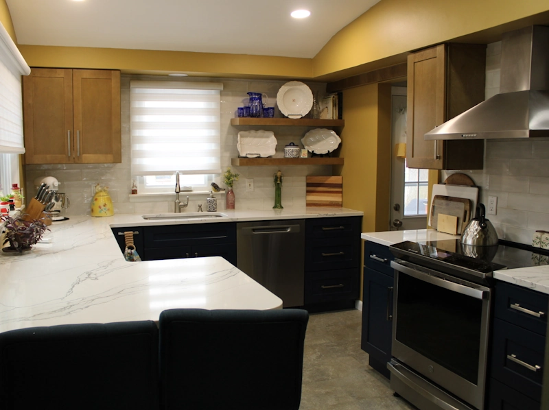 Kitchen remodel photo showing two-toned cabinets of dark blue on the bottom and light wood on the top